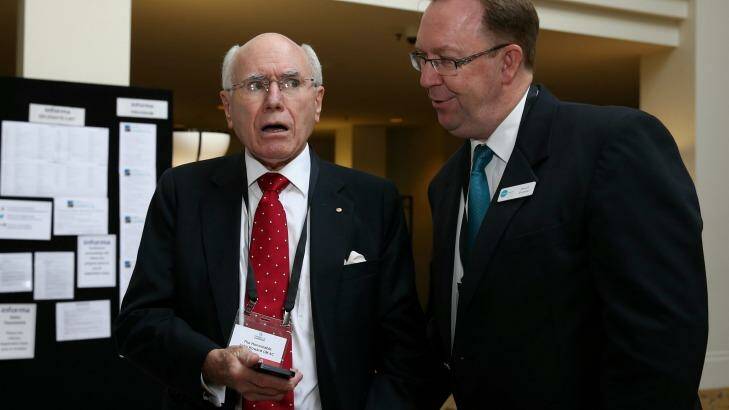 Steps Group Australia executive officer Stuart Coward shows former prime minister John Howard the fake Facebook page. Photo: Alex Ellinghausen