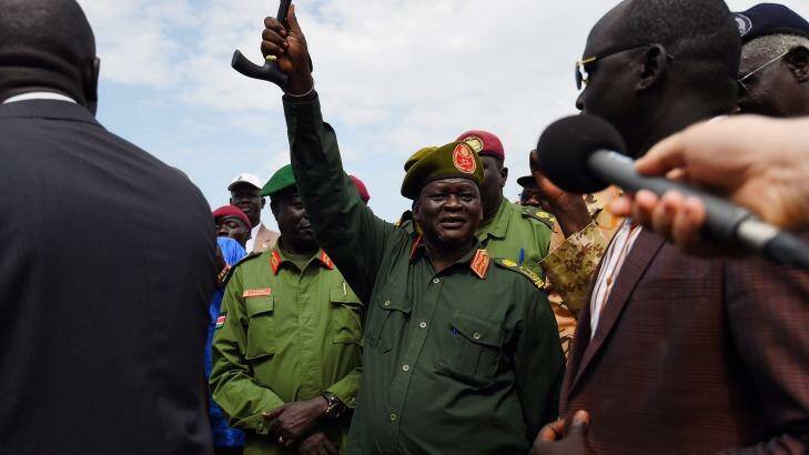 Lieutenant-General Simon Gatwech Dual (hand raised) greets supporters at Juba airport on Monday. Photo: Kate Geraghty