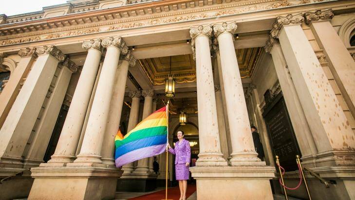 Sydney Lord Mayor Clover Moore with a rainbow flag outside Sydney Town Hall. Photo: Anna Kucera