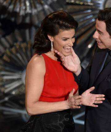 Idina Menzel, left, and John Travolta present the award for best original song at the Oscars at the Dolby Theatre in Los Angeles. Photo: John Shearer/Invision/AP