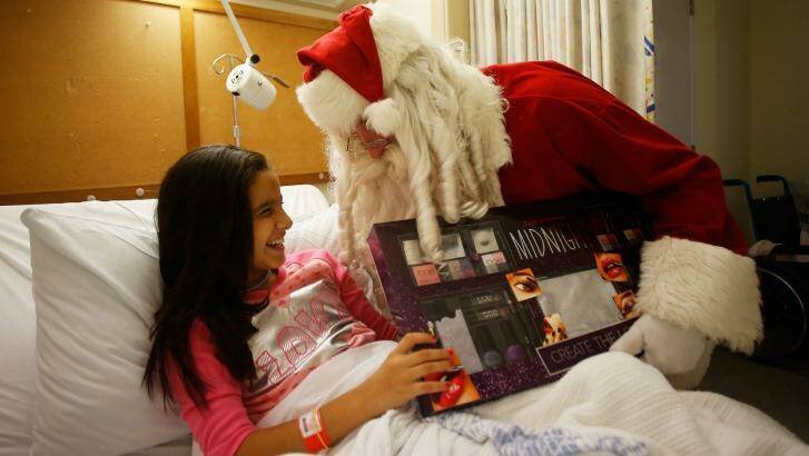 Zoe Labban receives a present from Santa on Christmas Day at Westmead Children's Hospital. Photo: Daniel Munoz