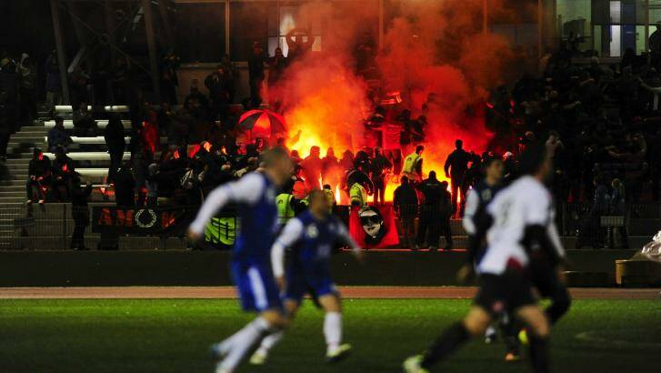 Wanderers supporters light flares into the crowd during a match against Canberra Olympic at the AIS last year.. Photo: Melissa Adams