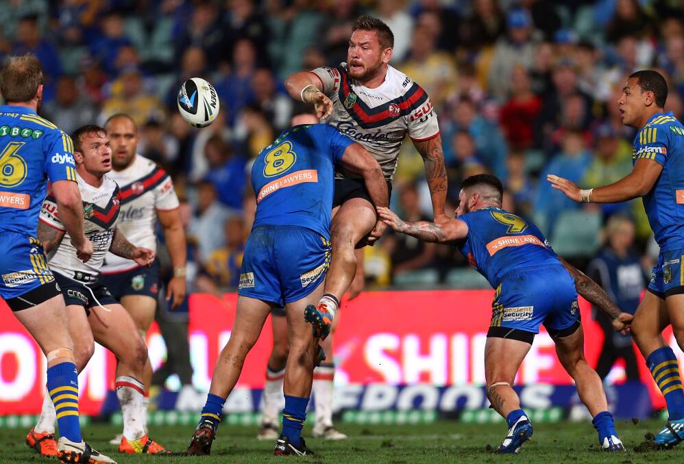 SYDNEY, AUSTRALIA - APRIL 12: Jared Waerea Hargreaves offloads the ball in a tackle by Tim Mannah during the round 6 NRL match between the Parramatta Eels and the Sydney Roosters at Pirtek Stadium on April 12, 2014 in Sydney, Australia. (Photo by Renee McKay/Getty Images)