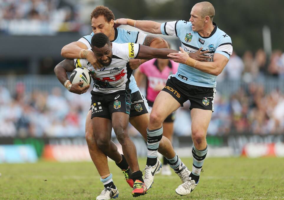 SYDNEY, AUSTRALIA - APRIL 26: James Segeyaro of the Panthers is tackled by Jeff Robson and Sam Tagataese of the Sharks during the round 8 NRL match between the Cronulla-Sutherland Sharks and the Penrith Panthers at Remondis Stadium on April 26, 2014 in Sydney, Australia. (Photo by Mark Metcalfe/Getty Images)