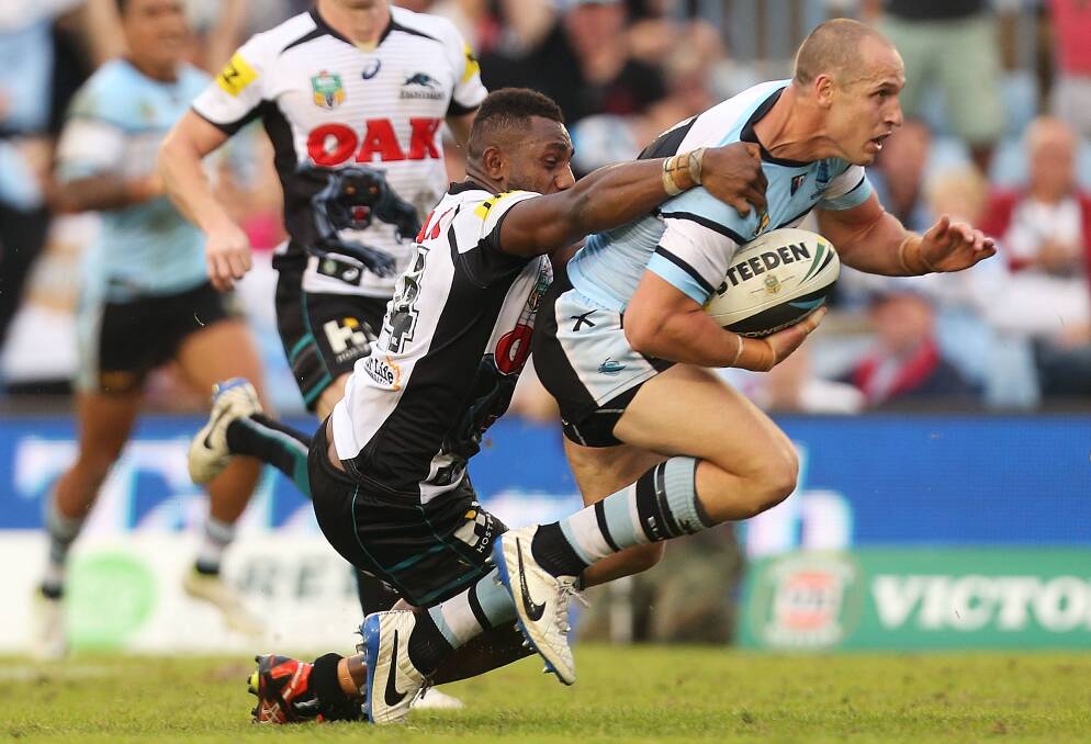 SYDNEY, AUSTRALIA - APRIL 26: Jeff Robson of the Sharks evades the attempted tackle of James Segeyaro of the Panthers to score the winning try during the round 8 NRL match between the Cronulla-Sutherland Sharks and the Penrith Panthers at Remondis Stadium on April 26, 2014 in Sydney, Australia. (Photo by Mark Metcalfe/Getty Images)