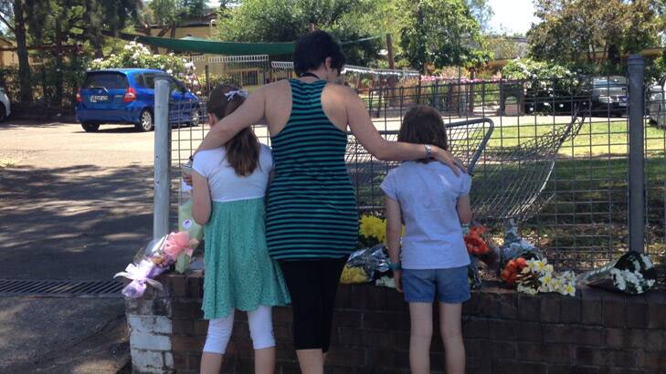 A mother and two of her children from Carlingford Public School leave flowers at the site of the crash. Photo: Amanda Hoh