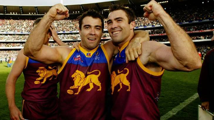Chris and Brad Scott celebrate the Brisbane Lions' 2002 flag wearing their famous premiership guernsey. Photo: Ray Kennedy